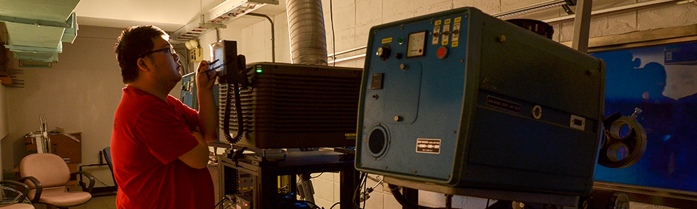 Classmates are operating machines in the background of the grand auditorium.